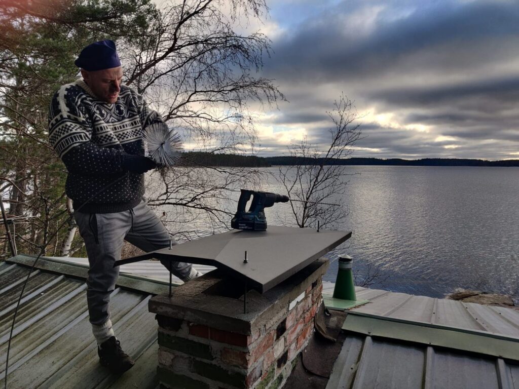 Nuohooja savupiipulla järven rannalla